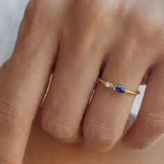 This exquisite ring features a captivating 0.07 ct marquise blue sapphire and a sparkling 0.02 ct round diamond of G color and VS clarity. Set on a delicate 1.35 mm band, this stackable ring is designed for everyday elegance, adding a touch of sophistication and brilliance to any look. Material: 14-karat solid gold Gold Colors: Yellow, rose, white Band Width: 1.35 mm Center Stones: 0.07 ct marquise blue sapphire and 0.02 ct round diamond Diamond Quality: G color, VS clarity Setting: Double stone Style: Stackable, dainty design perfect for everyday wear Design: Versatile and elegant, suitable for layering with other rings This beautiful ring is perfect for those who appreciate understated elegance and timeless design. Sapphire Ring Designs, Double Stone Ring, Blue Sapphire Wedding Band, Pretty Engagement Rings, Enchanted Jewelry, Sapphire Birthstone, Sapphire Wedding Band, Engagement Ring White Gold, Ringe Gold