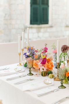 the table is set with flowers and candles