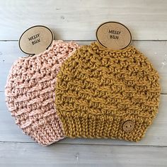 two crocheted beanies sitting next to each other on top of a wooden table