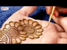 a woman is doing henna on her hands with a pen in it's hand