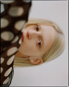 a woman with blonde hair and polka dots on her shirt