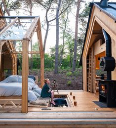 a woman sitting on the porch of a tiny cabin