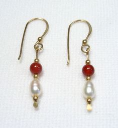 These earrings are Freshwater Pearl and Carnelian Agate. Their overall length including earwires is about 1 1/4". The Pearls are nicely shaped with good lustre, 5 mm in length. The Agate stones are 4 mm rounds. The pair shown is the one you will receive. Handmade by us.    Lyn's Jewelry, in business operating out of Sunny Syracuse since 1989. Red Carnelian Earrings With Ear Wire, Homemade Bead Earrings, Boho Jewelry Earrings, Italy Jewelry, Pearl Drop Earrings Gold, Freshwater Pearl Drop Earrings, Beaded Drop Earrings, Homemade Jewelry, Pearl Drop