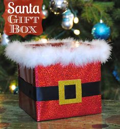 a santa gift box sitting in front of a christmas tree