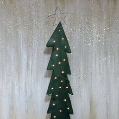 a green christmas tree with white lights on it and a star hanging from the top