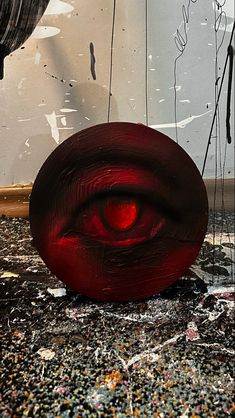 a red object sitting on top of a dirty floor