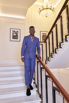 a man in a blue suit is standing on the stairs