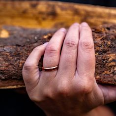 a person holding onto a piece of wood with their hand on the end of it