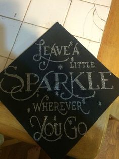 a black graduation cap that says leave a little sparkle wherever you go on the floor