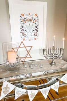 a hanukkah menorah is displayed on a mirrored table with candles