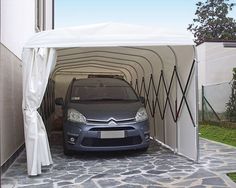 a car is parked in the garage with its door open and curtains pulled up over it