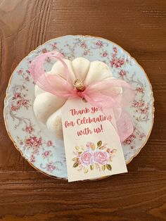 a plate with a card on it that says thank you for celebrating with us and sitting on a wooden table