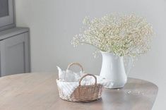 two vases filled with baby's breath flowers on top of a wooden table