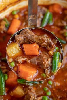 a ladle full of beef stew with carrots and green beans