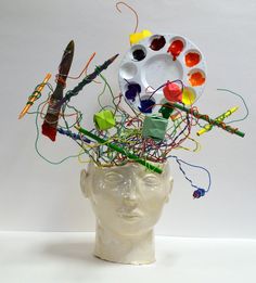 a white head with paintbrushes and other items in it