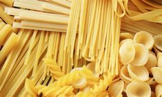 several different types of pasta are arranged together on the table, including one being uncooked