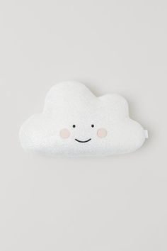 a white cloud pillow with a smiling face