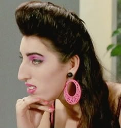 a woman with pink makeup and large earrings