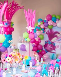 the table is set up with balloons, flowers and other decorations for a birthday party