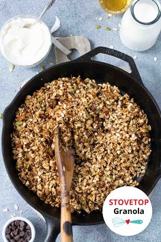 a skillet filled with granola next to chocolate chips and yogurt on the side