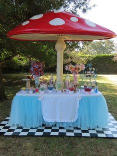 the table is set up with an umbrella and candy bar on it for a minnie mouse birthday party