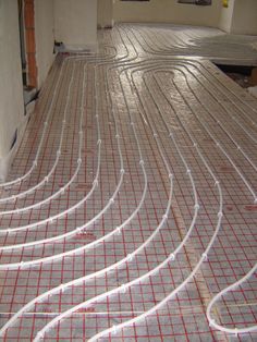 the floor is covered with white wire and red piping hoses on top of it