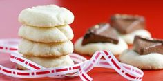 a stack of cookies sitting on top of a red table next to a white ribbon