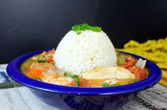 a blue bowl filled with rice and shrimp