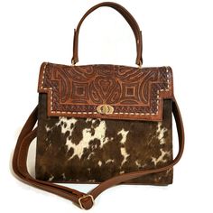 Featuring a gorgeous chiseled artisan design, this hair on leather bag will help you bring a little western flair to your everyday outfit. The perfect size for fitting all of your everyday essentials, this purse was actually handmade with love and care  with  talented  artisans  giving it a rustic touch that's hard to find in stores.  Crafted from genuine cowhide leather and best for casual and everyday wear.  height: 23cm. 9 inches width : 28cm.  11inches  base: 12cm.    4.5  inches  Adjustable Rustic Hand Tooled Shoulder Bag For Everyday, Western Style Brown Bags For Daily Use, Western Style Leather Rectangular Shoulder Bag, Western Style Brown Satchel Bag, Western Style Shoulder Bag For Everyday, Western Style Hand Tooled Shoulder Bag For Travel, Western Style Hand Tooled Brown Bag, Western Hand Tooled Bags For Daily Use, Hand Tooled Western Bags