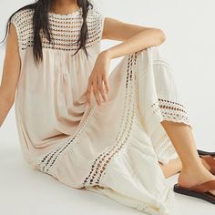 a woman sitting on the ground wearing sandals