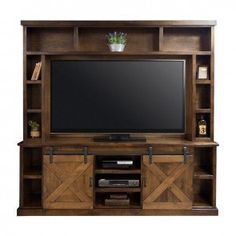 the entertainment center is made from wood and has sliding doors on both sides, with a flat screen tv mounted above it