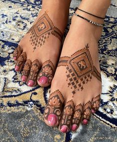 a woman's feet with henna tattoos on them