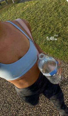 a woman in blue sports bra and leggings holding a water bottle