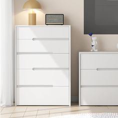 a white dresser sitting next to a lamp in a room