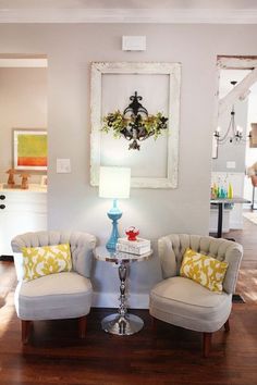 two chairs sitting next to each other on top of a hard wood floor in a living room