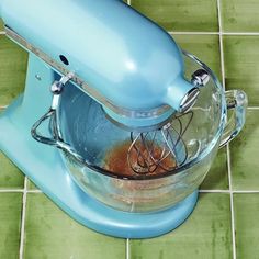 a blue mixer sitting on top of a green tile floor