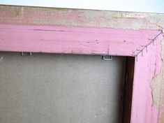 an old pink frame with some paint on it