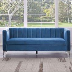 a blue couch sitting in front of a window