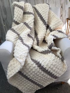 a crocheted blanket sitting on top of a white chair