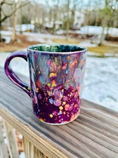 a colorful coffee cup sitting on top of a wooden table