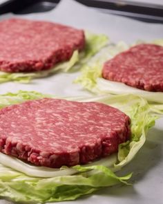 three hamburger patties sitting on top of lettuce