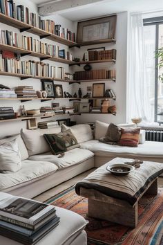 a living room filled with lots of furniture and bookshelves full of books on the wall