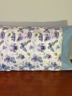 a blue and white pillow sitting on top of a wooden table