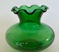 a green vase sitting on top of a white table