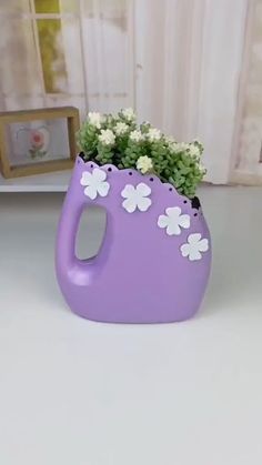 a purple vase with white flowers in it