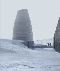 two people are walking in the snow near a building that is shaped like a cone