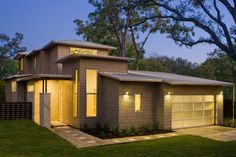 a house that is lit up in the evening with lights shining on it's windows