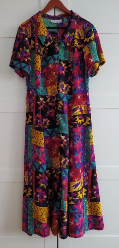 Beautiful dress with a large collar, made of rayon, fastened with decorative metal buttons. A small pull in the material between the buttons, visible in the photo where an additional snap is sewn in. The size on the label is S, but the dress is quite large, I think more M/L. Before ordering the product, please read the product dimensions, as they may differ from the information on the label. Measurements taken from seam to seam while the garment is lying flat. Please, note that displayed on the Fitted Multicolor Dresses With Button Closure, Retro Collared Multicolor Dresses, Vintage Multicolor Dresses With Buttons, Multicolor Vintage Print Dress, Long Vintage Dress, Retro Multicolor Vintage Print Dress, Vintage Multicolor Buttoned Dresses, Groovy Multicolor Retro Print Dress, Retro V-neck Dress With Vibrant Print