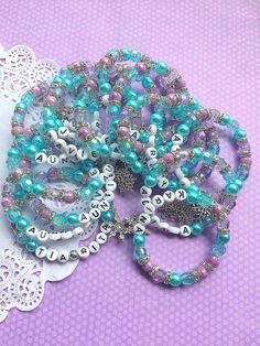 several bracelets with beads and charms on a doily next to a lace doily