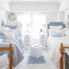 a bedroom with two twin beds and white carpeted flooring in front of a window